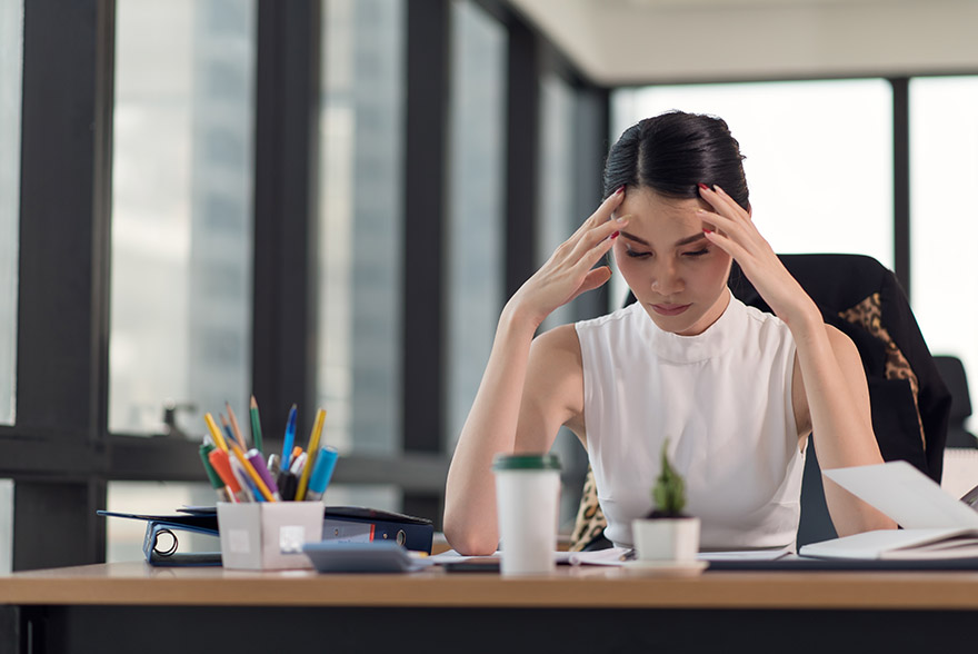 Portrait of stressed business woman with palm on face in her office